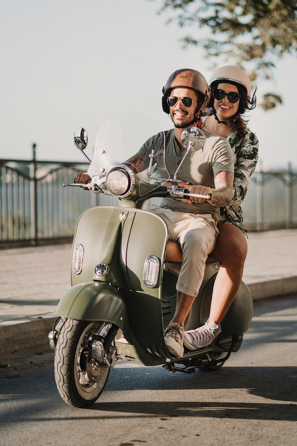 happy couple driving motoretta